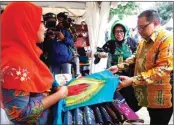  ?? BOY SLAMET/JAWA POS ?? BERKUALITA­S: Anak Agung Gede Ngurah Puspayoga (kanan) dan Fenny Apridawati melihat produk unggulan di stan Rosy Utari Rahayu (kiri) saat pembukaan Tanggulang­in Fair kemarin.