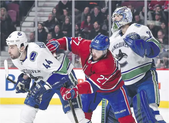  ?? — GETTY IMAGES ?? Vancouver’s Erik Gudgranson, left, battles with Alex Galchenyuk of the Montreal Canadiens in front of Canucks goaltender Anders Nilsson during Sunday’s game at the Bell Centre in Montreal. The 5-2 score for Montreal wasn’t indicative of how well...