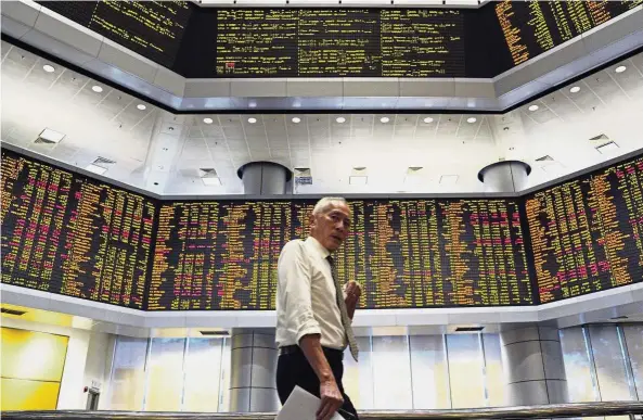  ??  ?? Market risks: A visitor at a private stock market gallery in Kuala Lumpur. Blue chips and big cap stocks in Malaysia have never been riskier not just because of the change in government and sentiment, but mainly because most were trading at very rich valuations. — AP