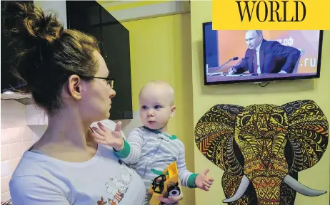  ?? YURI KADOBNOV / AFP / GETTY IMAGES ?? A woman watches a TV broadcast of Russian President Vladimir Putin’s annual press conference in Moscow on Thursday.