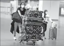  ?? PHOTO BY XINHUA ?? Travelers at Brasilia Internatio­nal Airport on Saturday comply with fresh rules on masks at Brazil’s airports and on planes as COVID-19 infections rise.