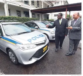  ?? FILE PHOTOS ?? Minister of National Security Robert Montague (left) and Cedric Allen, superinten­dent in charge of the Telecoms Division, examine newly acquired pre-owned police vehicles last November.