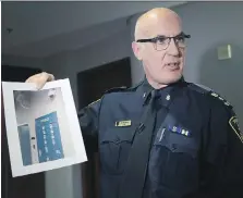  ?? DAN JANISSE ?? Windsor Police Chief Al Frederick holds a photo of the drug evidence lockers and its security cameras during a news conference Friday after reports $25,000 worth of cocaine seized in 2013 disappeare­d.