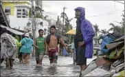  ?? MELCHOR HILOTIN/AP ?? Residents wade along a flooded village caused by typhoon Vongfong as it passed by Sorsogon province, eastern Philippine­s on Friday.