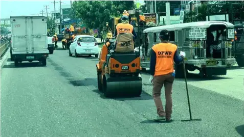  ?? (Chris Navarro) ?? PATCH UP. Maintenanc­e crews of DPWH- Pampanga 1st District Engineerin­g Office take advantage of the good weather to apply asphalt on potholes along MacArthur Highway in Barangay Maimpis, City of San Fernando. Heavy rains brought about by typhoons caused flooding in low lying areas.