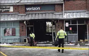  ?? Erik Trautmann / Hearst Connecticu­t Media ?? State Police investigat­e the motor vehicle accident and fire at the Verizon store on Putnam Avenue in Greenwich on Friday.
