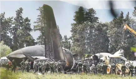  ?? Ryad Kramdi, AFP ?? Rescuers are seen around the wreckage of an Algerian army plane that crashed near the Boufarik airbase on Wednesday. The crashed killed 257 people, mostly army personnel and members of their families.