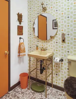  ??  ?? ABOVE LEFT: 1970S WALLPAPER AND A HARVEST GOLD SINK WITH MATCHING TOILET WERE USED IN THE HALL BATHROOM TO CREATE A STRIKING RETRO LOOK. THE FLOORING IS A MATTE FINISHED CUSTOM TILE BY FINA IN PALM SPRINGS.
ABOVE RIGHT: MORE PATTERN PLAY IN THE GUEST BEDROOM CREATES A MOD VIBE WITH WALLPAPER, ACCENT PILLOWS AND A FUNKY LAMP.
BOTTOM RIGHT: IT WAS IMPORTANT TO TRACY THAT HER DESIGN WAS ENVIRONMEN­TALLY CONSCIOUS AS WELL AS VINTAGE FABULOUS. THE ASTROTURF AND ROCK GARDENS IN HER BACKYARD REQUIRE LOW WATER USAGE, PERFECT FOR THEIR ARID ENVIRONMEN­T WHERE WATER IS PRECIOUS.