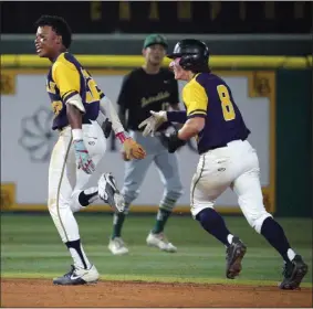  ?? PHOTO BY SCOTT VARLEY ?? Millikan’s Cameron Hegamin, left, is chased by teammate Sam DeCarlo after delivering the game-winning hit in Wednesday’s 1-0Moore League victory over Poly.