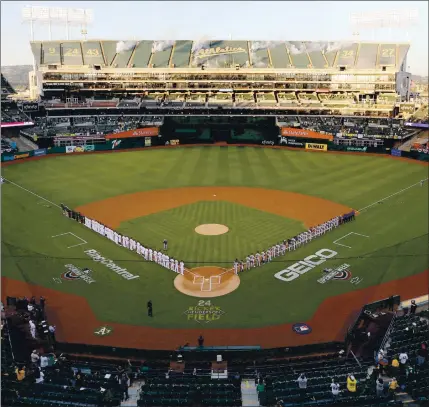  ?? RAY CHAVEZ — STAFF PHOTOGRAPH­ER ?? The Houston Astros and A’s line up for the national anthem before the season opener Thursday night at the Coliseum.