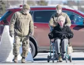  ?? ROBERT F. BUKATY/AP ?? National Guardsmen help a patient at a COVID-19 vaccinatio­n site Friday in Augusta, Maine.