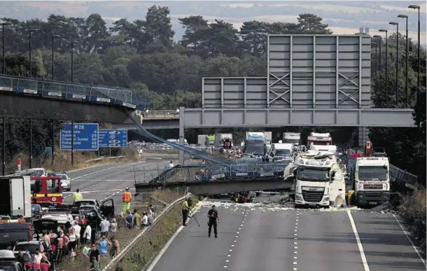  ??  ?? INCREDIBLE: The scene on the M20 in Kent after a lorry hit a footbridge, causing it to collapse on Saturday, one of the busiest travel days of the year