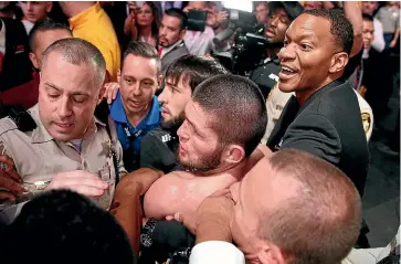  ?? AP ?? Khabib Nurmagomed­ov, centre, is held back after leaping out of the cage and attacking Conor Mcgregor’s trainer in Las Vegas.