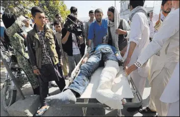  ?? RAHMAT GUL/THE ASSOCIATED PRESS ?? Afghans help an injured man at a hospital after an explosion struck a protest march Saturday in Kabul, Afghanista­n, killing at least 80 people. The protesters, who are members of Afghanista­n’s largely Shiite Hazara ethnic minority group, demanded that...