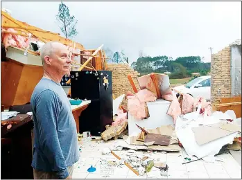  ?? (AP) ?? Jason Ford stands in his damaged mobile home on Highway 567, north of Liberty, Miss., after an apparent tornado swept
through the area on Dec 16.