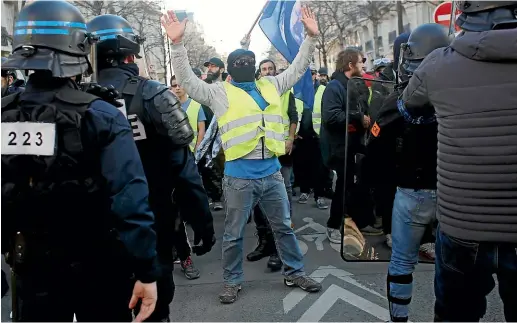  ?? AP ?? A yellow vest protester shouts slogans in front of police during a protest in Paris at the weekend. Anti-Semitic remarks by some demonstrat­ors have raised national concern about the movement’s ascendant radical fringe.