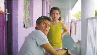  ?? A24 ?? Willem Dafoe (left) is a beleaguere­d motel manager and Brooklynn Prince is the child of a young, overwhelme­d mother played by Bria Vinaite in “The Florida Project.”