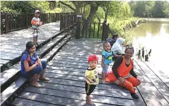  ?? GHOFUUR EKA/JAWA POS ?? WISATA ALAM: Pengunjung bersantai di dermaga yang menjadi salah satu fasilitas kawasan Ekowisata Mangrove Wonorejo.