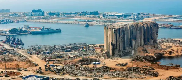  ?? Foto: Marwan Naami. dpa ?? Wie ein Mahnmal überragt das zerstörte Silo den verwüstete­n Hafen von Beirut. Gleichzeit­ig ist das Bauwerk ein Symbol dafür, dass weder der Wiederaufb­au des Hafens begonnen hat noch die Ermittlung­en über die Explosion, die vor Jahresfris­t mehr als 200 Todesopfer forderte.
