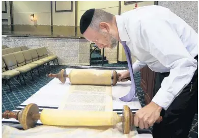  ?? CARLINE JEAN/STAFF PHOTOGRAPH­ER ?? Rabbi Efrem Goldberg, of Boca Raton Synagogue, examines Torahs which will be housed at his congregati­on.