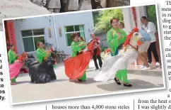  ??  ?? Farmers in green traditiona­l costumes greet visitors with dance performanc­es in Hu County.