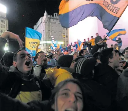  ?? E.FERNANDEZ ?? Cita obligada. Cientos de hinchas de Boca llevaron su felicidad al Obelisco. Hubo fiesta azul y oro.