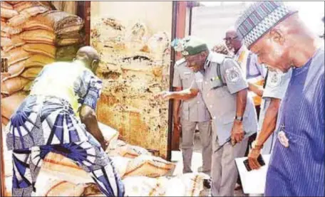  ??  ?? Ali and other customs officials inspecting a container load of expired and rotten bags of rice