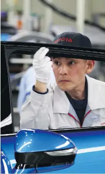  ?? TOMOHIRO OHSUMI/BLOOMBERG FILES ?? A Toyota Motor Corp. worker inspects a Mirai fuel-cell vehicle at its plant in Japan. Toyota is joining the race to develop advanced technology through its partnershi­p with Mazda.