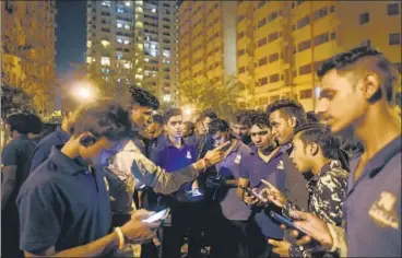  ?? BURHAAN KINU/HT PHOTO ?? Workers gather at DLF Capital Greens housing complex in Moti Nagar on Sunday night.