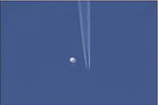  ?? BRIAN BRANCH VIA AP ?? In this photo provided by Brian Branch, a large balloon drifts above the Kingston, N.C. area, with an airplane and its contrail seen below it.