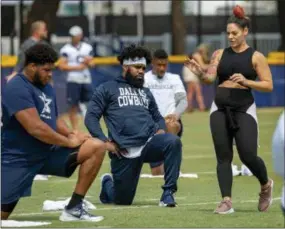  ?? GUS RUELAS — ASSOCIATED PRESS FILE PHOTO ?? In this July 28, 2018, file photo, Dallas Cowboys offensive tackle La’el Collins, left and running back Ezekiel Elliott, center, listen to yoga instructor Stacey Hickman, right, as the team does some flexibilit­y exercises at NFL football training camp in Oxnard, Calif.