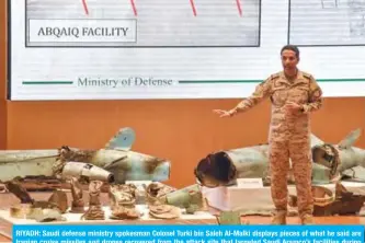  ?? — AFP ?? RIYADH: Saudi defense ministry spokesman Colonel Turki bin Saleh Al-Malki displays pieces of what he said are Iranian cruise missiles and drones recovered from the attack site that targeted Saudi Aramco’s facilities during a press conference yesterday.