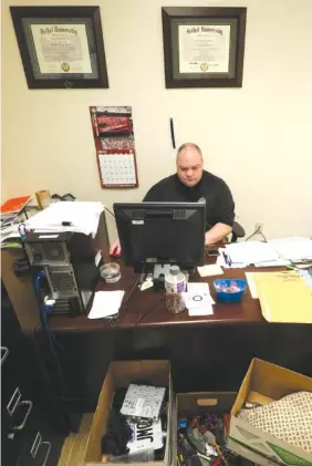  ?? STAFF PHOTO BY DAN HENRY ?? Detective Brad Brown works in an office cluttered with evidence boxes Thursday at the Chattanoog­a Police Department.