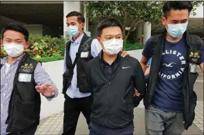  ?? (AP) ?? Ryan Law (third from left), Apple Daily’s chief editor, is escorted Thursday by police officers in Hong Kong after his arrest on suspicion of colluding with a foreign country, according to media reports.
