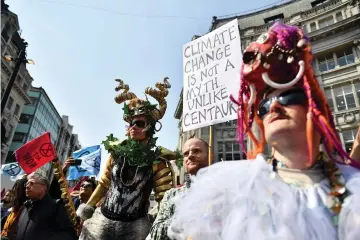  ??  ?? Environmen­tal protesters from the Extinction Rebellion group in fancy dress gather at Oxford Circus as they take part in a demonstrat­ion at the junction of Oxford Street and Regent Street in London. — AFP photo