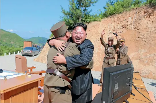  ?? PHOTO: REUTERS ?? North Korean leader Kim Jong Un reacts with scientists and technician­s of the DPRK Academy of Defence Science after the test-launch of the interconti­nental ballistic missile Hwasong-14.