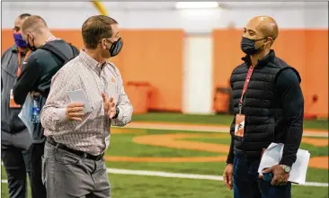  ?? COURTESY OF DAVID PLATT/CLEMSON ATHLETICS ?? Falcons general manager Terry Fontenot (right), talking with Clemson coach Dabo Swinney last month, says teams usually hold mock drafts as the NFL draft approaches.