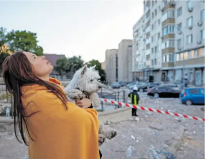  ?? ?? Rusi tvrde da su oborili sve dronove lansirane na Moskvu pa su oštećenja na stambenim zgradama izazvali njihovi ostaci, a isto tvrde i Ukrajinci za projektile kojima Rusi udaraju po Kijevu. Fotoreport­er Reutersa snimio je djevojku sa psom u Kijevu na mjestu napada dronom