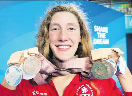  ?? RYAN REMIORZ/THE CANADIAN PRESS ?? Taylor Ruck, a native of Kelowna, B.C., holds her eight swimming medals at the Commonweal­th Games last week in Gold Coast, Australia. The 17-year-old swimmer was one of Canada’s bright spots at the games, winning one of the country’s 15 gold medals —...