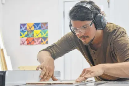  ?? DANIEL BROWN/THE GUARDIAN ?? Brandon Hood, office manager of Nine Yards Studio, runs some wood through the buzz saw in their firm’s Secret Design Bunker. The office and bunker is located on the corner of Queen and Fitzroy Street in Charlottet­own.