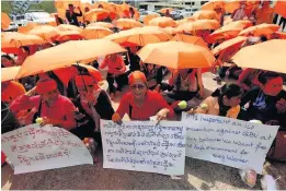  ??  ?? BROLLY GOOD SHOW Feminist campaigner­s in Cambodia’s Phnom Penh