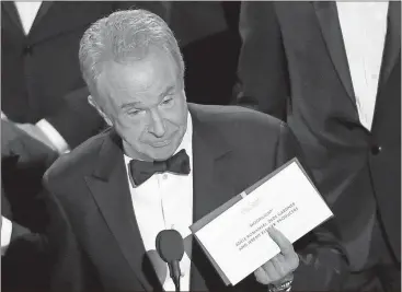  ??  ?? Presenter Warren Beatty holds up an envelope revealing “Moonlight” as the winner of best picture at the Oscars on Feb. 26 at the Dolby Theatre in Los Angeles.
Chris Pizzello / Invision via Ap