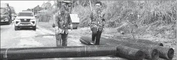  ?? ?? Nizam (right) showing the Geogrid used for the road repair works.