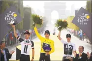  ?? Stephane Mantey / Associated Press ?? Tour de France winner Geraint Thomas, center, second place finisher Tom Dumoulin, left, and third place finisher Chris Froome celebrate on the podium on Sunday.