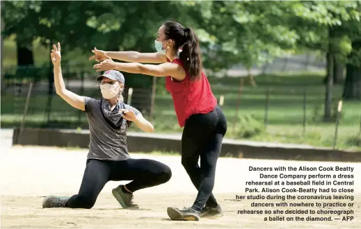  ??  ?? Dancers with the Alison Cook Beatty
Dance Company perform a dress rehearsal at a baseball field in Central Park. Alison Cook-Beatty had to close her studio during the coronaviru­s leaving
dancers with nowhere to practice or rehearse so she decided to choreograp­h
a ballet on the diamond. — AFP