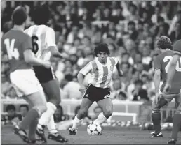  ?? Getty Images/tns ?? Argentina player Diego Maradona (center) takes on the Belguim defense during the 1982 FIFA World Cup match between Argentina and Belguim at the Nou Camp stadium on June 13, 1982 in Barcelona, Spain.