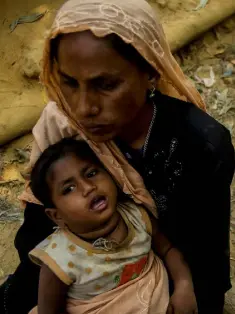  ??  ?? DRIVEN OUT: A Rohingya muslim mother with her child waiting for humanitari­an aid in a camp in Bangladesh