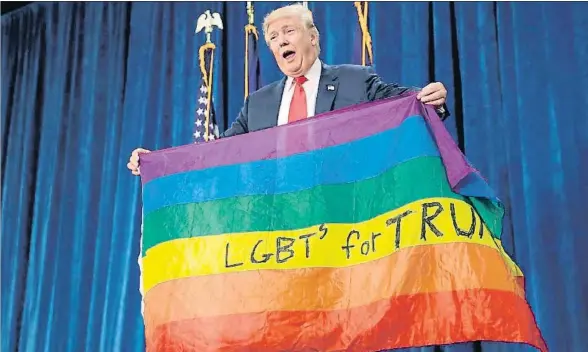  ?? CHIP SOMODEVILL­A / GETTY / ARCHIVO ?? Trump mostrando una bandera del colectivo de gais y transexual­es durante un acto electoral en Colorado, en octubre del año pasado