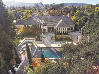  ?? Photos by Open Homes Photograph­y ?? Above: This aerial shot of 125 Stephanie Lane in Alamo showcases the estate’s expansive backyard with a raised spa and Pebble Tec lap pool. Below left: The home opens to a grand foyer with a double-height ceiling and a curved staircase. Below right:...