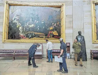  ?? AFP ?? Miembros de la Oficina del Arquitecto del Capitolio revisan daños en las obras de la colección.